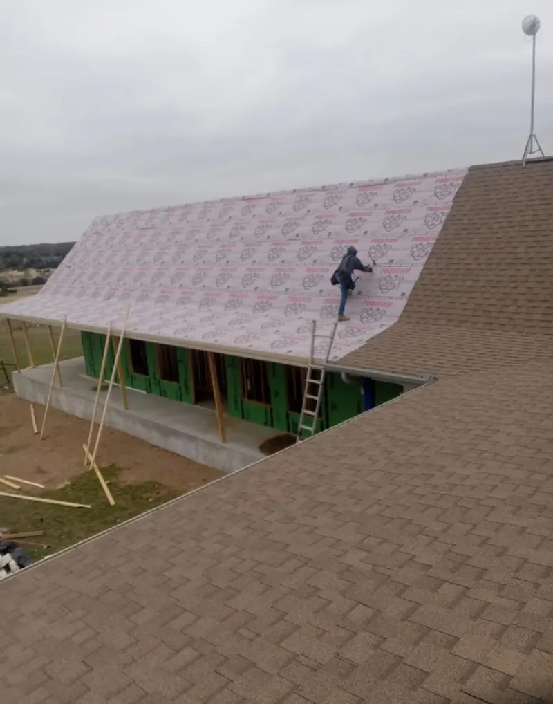 Worker preparing underlayment for a metal roof installation in Anaconda-Deer Lodge County